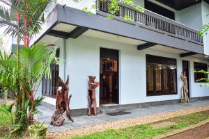 a white house with wooden sculptures in front of it at Wicks Backpacker's Lodge - Peaceful Quality stay, Walk to the Historic Galle Dutch Fort and the beach in Galle