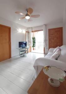 a living room with a bed and a tv at APARTAMENTOS ROSI - 5-10 Minute Walk To La Zenia Beach, Sea View, Beach Bar, Cliff Walk, Shops, Paddys Point, Cabo Roig - Free fast Fibre Optic Broadband, Free Parking, Tassimo coffee machine, TV Firestick compatible in Playas de Orihuela