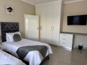 una camera da letto con un letto e una TV a schermo piatto di Aluz Guestunit, Self-catering a East London