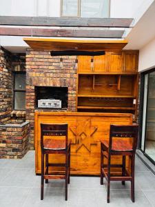 una cucina con due sedie e un camino di Aluz Guestunit, Self-catering a East London