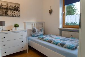 a small bedroom with a bed and a dresser at NEU! Reiterhof Finkenmühle Fewo Balou in Weißenstadt