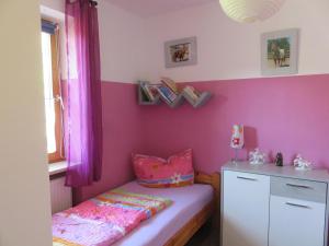 ヴァイセンシュタットにあるNEU! Reiterhof Finkenmühle Fewo Romano mit Balkonのピンクの壁の子供用ベッドルーム(ベッド1台付)