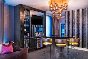 a bar in a room with a couch and a chandelier at THE MIDLAND HOTEL, Chicago, a Tribute Portfolio Hotel in Chicago