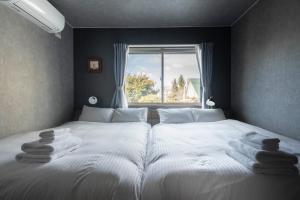 a bedroom with two beds and a window at The Gracious in Sapporo