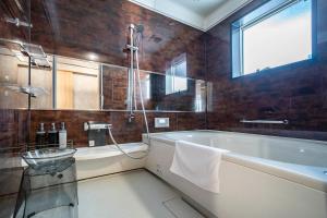 un bagno con vasca e finestra di The Gracious a Sapporo