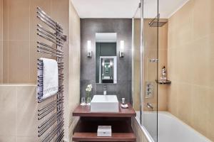 a bathroom with a sink and a bath tub at Hôtel Barrière Le Gray d'Albion in Cannes