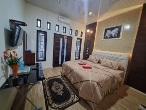 a bedroom with a large bed and a desk at Alya Homestay Meulaboh in Meulaboh