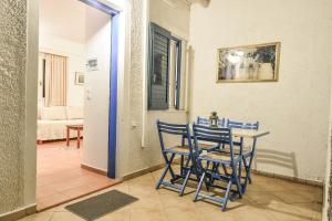 a dining room with blue chairs and a table at Green Village in Xylokastro