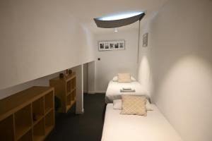 een kleine kamer met 2 bedden en een licht bij Homenfun Barcelona Vallcarca in Barcelona
