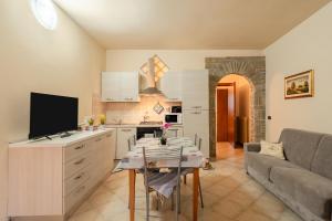 a kitchen and living room with a table and a couch at Casa Angeli - By The River in Lucca