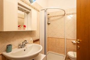 a bathroom with a sink and a shower at Casa Angeli - By The River in Lucca +12 photos