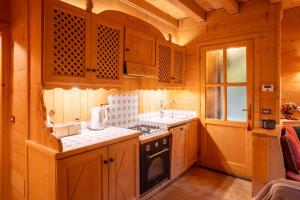 una cucina con mobili in legno e un forno a piano cottura di La casa di Francesco - vicino alle piste da sci a Pezzo Altre 6 foto