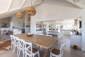 a kitchen and dining room with a wooden table and chairs at Simply Stunning but smaller in Cape St Francis