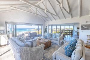a living room with couches and a view of the ocean at Simply Stunning but smaller in Cape St Francis