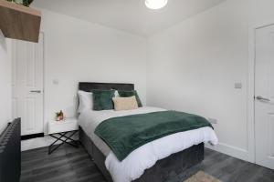 a bedroom with a bed with a green blanket at The Modern Retreat in Leicester