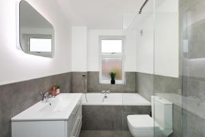 a white bathroom with a sink and a toilet at The Modern Retreat in Leicester