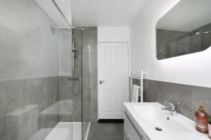 a bathroom with a shower and a sink and a mirror at The Modern Retreat in Leicester +29 photos