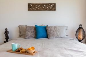 a bed with a tray of bread and a cup of coffee at 2br boutique style villa Lipe in Bang Rak Beach