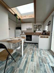 a kitchen with white cabinets and a table and chairs at La petite saline in Le Croisic