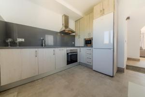 a kitchen with white cabinets and a white refrigerator at Villas Flamenco Beach Conil in Conil de la Frontera