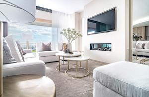 a white living room with a couch and a tv at LO- Los Olivos Benahavis by Roomservices in Benahavís