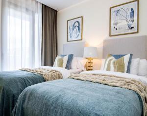 two beds in a hotel room with a window at LO- Los Olivos Benahavis by Roomservices in Benahavís +38 photos