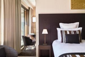 a hotel room with a bed and a chair at Hôtel Barrière Le Gray d'Albion in Cannes