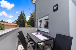 a table and chairs on the balcony of a building at Holiday Home Sea in Premantura