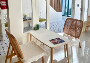 a table and chairs with a book on it at My Uthai Hotel in Ban Khok Mo