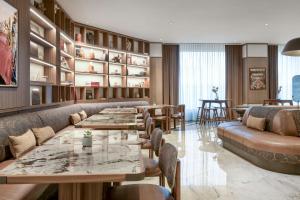 ein Restaurant mit Tischen, Sofas und Stühlen in der Unterkunft AC Hotel Milano by Marriott in Mailand