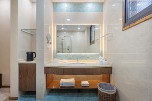 un bagno con lavandino e specchio di Nanjing Orchid Garden B&B a Gaochun
