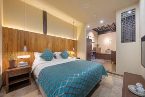 una camera da letto con un letto grande con una coperta blu di Nanjing Orchid Garden B&B a Gaochun