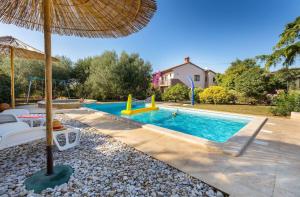 una piscina con ombrellone e parco giochi di Sabi Relax Zone - Pool & Jacuzzi a Pola (Pula)
