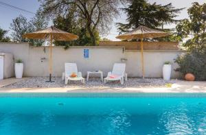 due sedie e ombrelloni accanto a una piscina di Sabi Relax Zone - Pool & Jacuzzi a Pola (Pula)