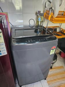 a washing machine with a sink on top of it at Laxmi Happy Home in Pune in Pune +19 photos