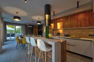 a kitchen with a bar with chairs and a table at Pieron & Bavigo Villas - Spa Oasis in Marčana