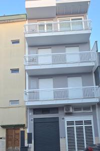 an apartment building with a balcony and a garage at Case Vacanze 106 Maison De Charme in Giovinazzo