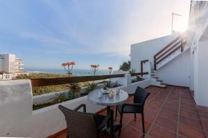 a balcony with a table and chairs and the ocean at Villas Flamenco Beach Conil in Conil de la Frontera