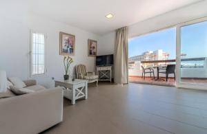 a living room with white furniture and a large window at Villas Flamenco Beach Conil in Conil de la Frontera