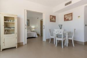 a white room with a table and a bedroom at Villas Flamenco Beach Conil in Conil de la Frontera