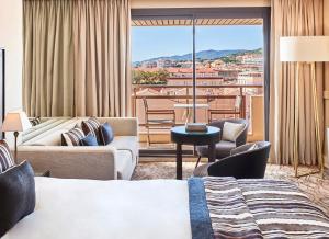 a hotel room with a view of a city at Hôtel Barrière Le Gray d'Albion in Cannes