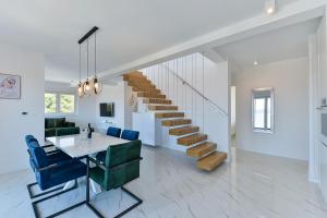 een woonkamer met een trap en een tafel en stoelen bij Villa DIV with pool in Bibinje