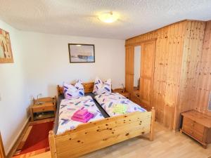 Un dormitorio con una cama y una pared de madera. en Ferienwohnung Wanke, en Ribnitz-Damgarten