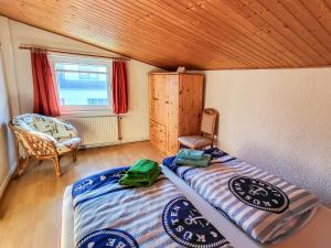Un dormitorio con dos camas y una silla y una ventana. en Ferienwohnung Wanke, en Ribnitz-Damgarten