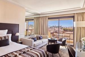 a hotel room with a bed and a balcony at Hôtel Barrière Le Gray d'Albion in Cannes