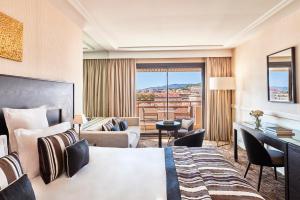 a hotel room with a bed and a desk at Hôtel Barrière Le Gray d'Albion in Cannes
