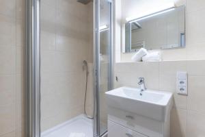 een witte badkamer met een wastafel en een douche bij Ferienwohnung Richter in Oberstdorf +8 foto's