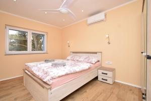 Un dormitorio con una cama y un ventilador de techo. en Villa Blue Chill, en Brodarica 36 fotos más