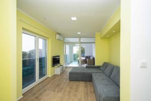 Una sala de estar con un sofá y un televisor. en Villa Blue Chill, en Brodarica
