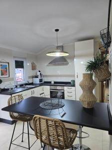 a kitchen with a black table and chairs at Apartamento en el centro de Cedeira nuevo y con terraza in Cedeira
